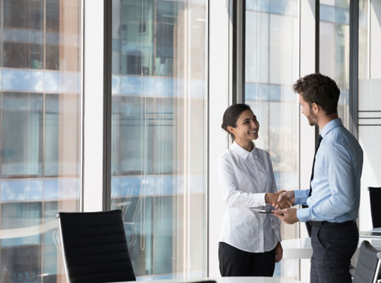 two people shaking hands in an office